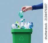 Small photo of Woman putting a plastic bottle in a full recycling bin, separate waste collection concept