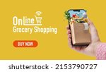Woman ordering her grocery online, she is holding a smartphone with a small grocery bag full of goods, banner with copy space