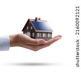 Small photo of Hand holding an energy efficient model house with solar panels, ecology and sustainability concept On white backgroundbackground