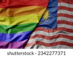 big waving realistic national colorful flag of malaysia and rainbow gay pride flag . macro
