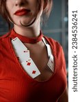 Small photo of poker girl in a dress with a neckline in which poker cards look seductively on a woman's chest. poker gambling. women's neckline