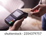 Small photo of NFC credit card payment. Woman paying with contactless credit card with NFC technology. Wireless money transaction. Card machine in male hand on sunlight background