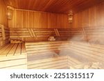 Interior of Finnish sauna, classic wooden sauna with hot steam. Russian bathroom. Relax in hot sauna with steam. Wooden interior baths, wooden benches and loungers accessories for sauna, spa complex.