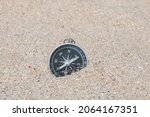 Small photo of Classic navigation compass on beach as symbol of tourism with compass, travel with compass and outdoor activities with compass