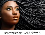 Close up cosmetic beauty portrait of african woman showing long black braided hairstyle.