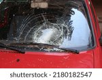 Broken windshield on car photo. Traffic accident with crash glass on vehicle image. Strong impact on automobile. Car damaged consequences after heavy storm.