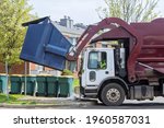 Small photo of Red truck with a loading household container home maintenance public services on the street