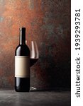 Small photo of Bottle of red wine with old empty label on rusty brown background. Frontal view with space for your text.