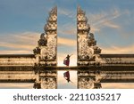 Balinese women in traditional costumesis standing in the gate of Lempuyang temple on Bali island, Indonesia