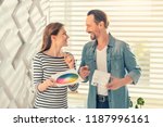 Small photo of Need your advice. Joyful female looking at her partner while holding color map