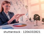 Small photo of Color map. Beautiful female person expressing positivity while sitting at her workplace