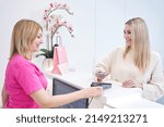 Small photo of Joyous beauty salon customer making contactless payment at reception desk