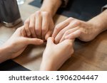 Small photo of Hands of young amorous and affectionate dates sitting by served table during romantic dinner in contemporary restaurant or cafe