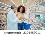 Small photo of Happy talkative woman, having a conversation with a male pharmacist.