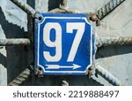 Small photo of Weathered grunge square metal enameled plate of number of street address with number 97
