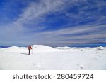 Woman on touring skis isolated on alpine plateau in sunny winter day