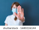 Coronavirus concept. Girl wearing mask for protection from disease and show stop hands gesture for stop corona virus outbreak. Global call to stay home