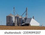Small photo of silver silos on agro manufacturing plant for processing drying cleaning and storage of agricultural products, flour, cereals and grain. Large iron barrels of grain. Granary elevator in Brazil