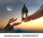 Small photo of Ornamental Arabic lantern with burning candle glowing in hand. Festive greeting card, invitation for Muslim holy month Ramadan Kareem.