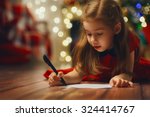 small child writes the letter to Santa