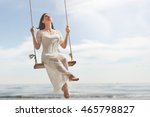 beautiful young woman on a swing on summer day outdoors
