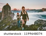 Couple travelers holding hands hiking together in Norway travel healthy lifestyle concept active vacations outdoor Segla mountain sunset landscape