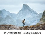 Man hiking in mountains traveling solo with backpack outdoor active vacations in Norway healthy lifestyle extreme sports