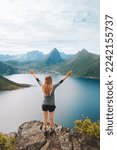 Woman hiking in Norway active travel adventure vacations outdoor healthy lifestyle girl on the top of mountain success raised arms, exploring Senja island