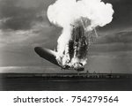 Small photo of Left side view of German airship 'Hindenburg' burning, at Lakehurst, N.J., May 6, 1937. Hindenburg used flammable hydrogen for lift, which incinerated the airship in a massive fireball in less than 30