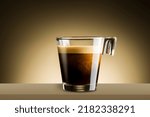 Black coffee in glass cup on brown background