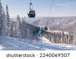 ski lift in mountain ski resort, winter day, snowy spruce forest