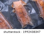 Small photo of freeze cooked salmon in vacuum packs on grunge table, concept of food preservation, good work from home lunch idea, quick food for easily justify eating on bysy day, time-saving meal, close up view
