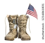 Small photo of Old military combat boots with the American flag and dog tags, isolated on white background. Memorial Day or Veterans day concept.