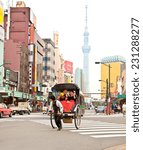 Small photo of TOKYO, JAPAN-OCT 27,2014: Jinrikisha driven by an unidentified driver carrying two Japanese tourists in Tokyo,Japan.The word jinrikisha is of Japanese origin and means human-powered vehicle.