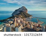 Drone point of view Rock of Penon de Ifach, harbor, Mediterranean sea rooftops of houses Calp cityscape. Coastal town located in comarca of Marina Alta province of Alicante Valencian Community, Spain