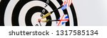 Small photo of Close up dartboard with two darts in a bullseye, Great Britain and USA unites states of America, leadership tussle and struggle concept image, copyspace for your text white background, concept image