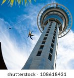 Auckland Sky Tower from below with blue sky and someone jumping off