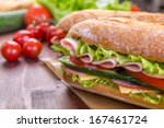 Ciabatta Sandwich with lettuce, slices of fresh tomatoes, cucumber, ham, salami and cheese