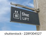 Small photo of A sign informing about the presence of an elevator for ascent and descent. In English and Hindi it is written "Lift".