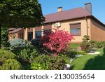 Backyard garden with nicely trimmed bonsai, bushes and stones in front of the European style villa. Landscape design. High quality photo