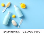 Baby bathing accessories and shampoo bottles on blue table. Flat lay. Top view