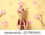 Bouquet of flowers from paper in the hands of mom. Mothers Day holiday concept