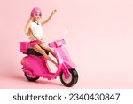 Small photo of Grodno, Belarus - July 30, 2023: Barbie doll says hello riding pink vintage scooter.