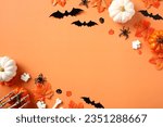 Happy Halloween concept. Scary bats silhouettes, pumpkins, spiders, fallen leaves on orange background.