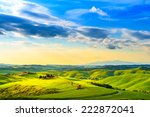 Tuscany, rural sunset landscape. Countryside farm, cypresses trees, green field, sun light and cloud. Volterra, Italy, Europe.