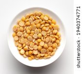 Small photo of Macro Close-up of Organic arhar dal (Cajanus cajan) or split yellow dal inside a ceramic white bowl. Top view