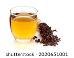 Small photo of Close-Up of organic boiled water (Tea or kada ) of clove (syzygium aromaticum ) in a transparent glass cup over white background. Original residue in bottom of tea cup