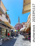 Small photo of Rhodes, Greece - July 04, 2021: sightseeing place at hot summer sunshine afternoon. Socrates str in Old Rhodes Town - street market with shops, restaurants, and hundreds of tourists and vacationers.