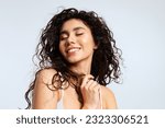 Happy young woman with natural beauty, and beautiful curly hair closed her eyes with pleasure