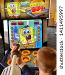 Small photo of Roseville, CA - May 25, 2019: Young boy playing a Sponge Bob Squarepants Order Up Whack A Burger game at Chuck E Cheese.